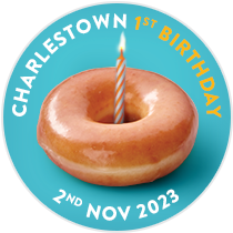 A single Original Glazed Doughnut with a candle in the middle to signify the Charlestown Store's first Birthday, celebrating a year in this location