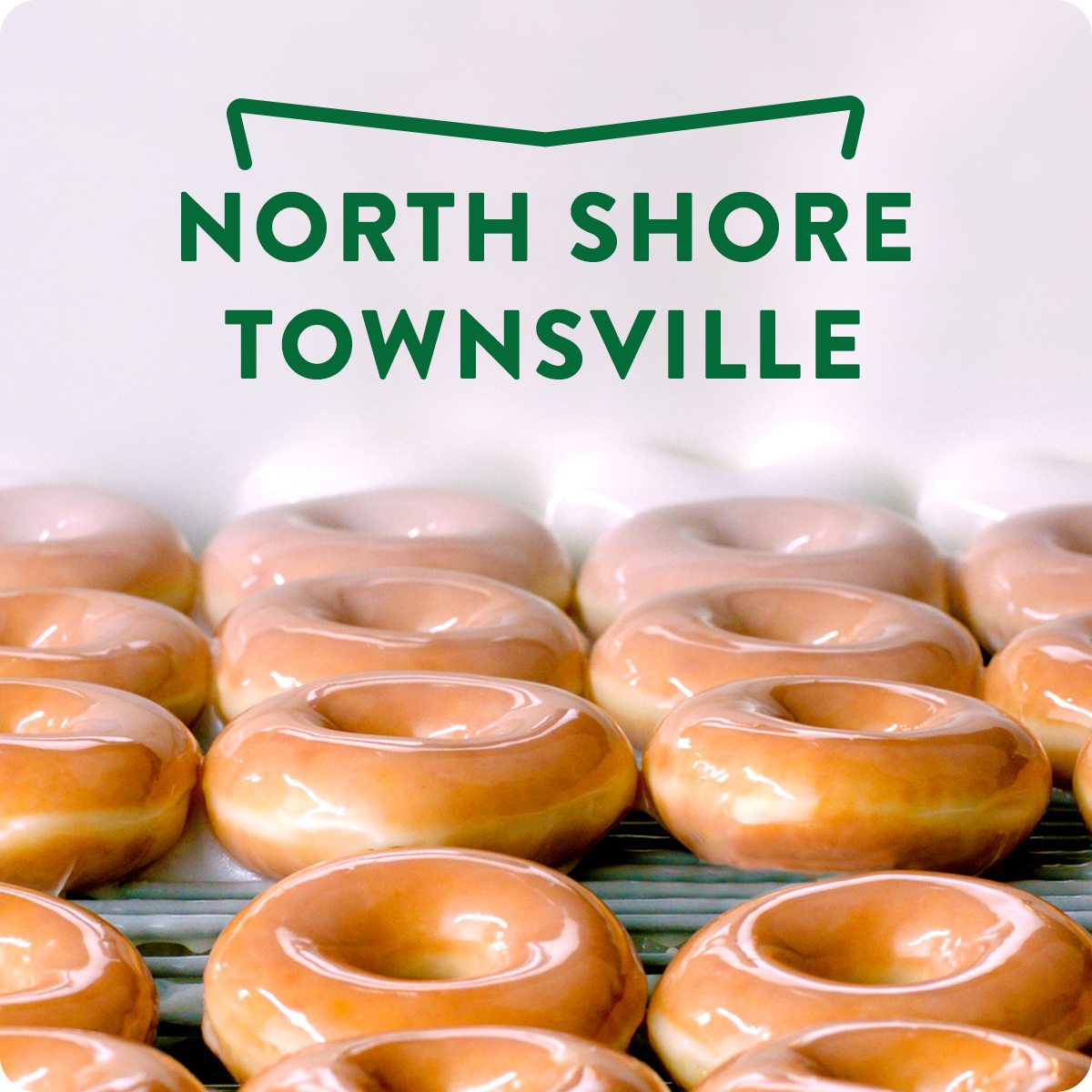 Fresh Original Glazed doughnuts coming down the line with a heading 'North Shore Townsville'
