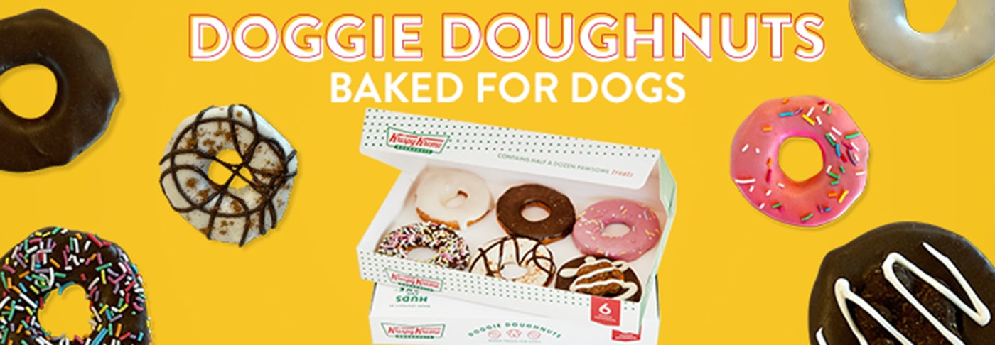 Krispy Kreme Doggie Doughnuts - Celebrate your Fur-Friend with Treats baked just for them! Pet Food Only Krispy kreme Doggie Doughnuts pictured with a Pug dog licking his lips surrounded by floating Doggie Doughnut Products